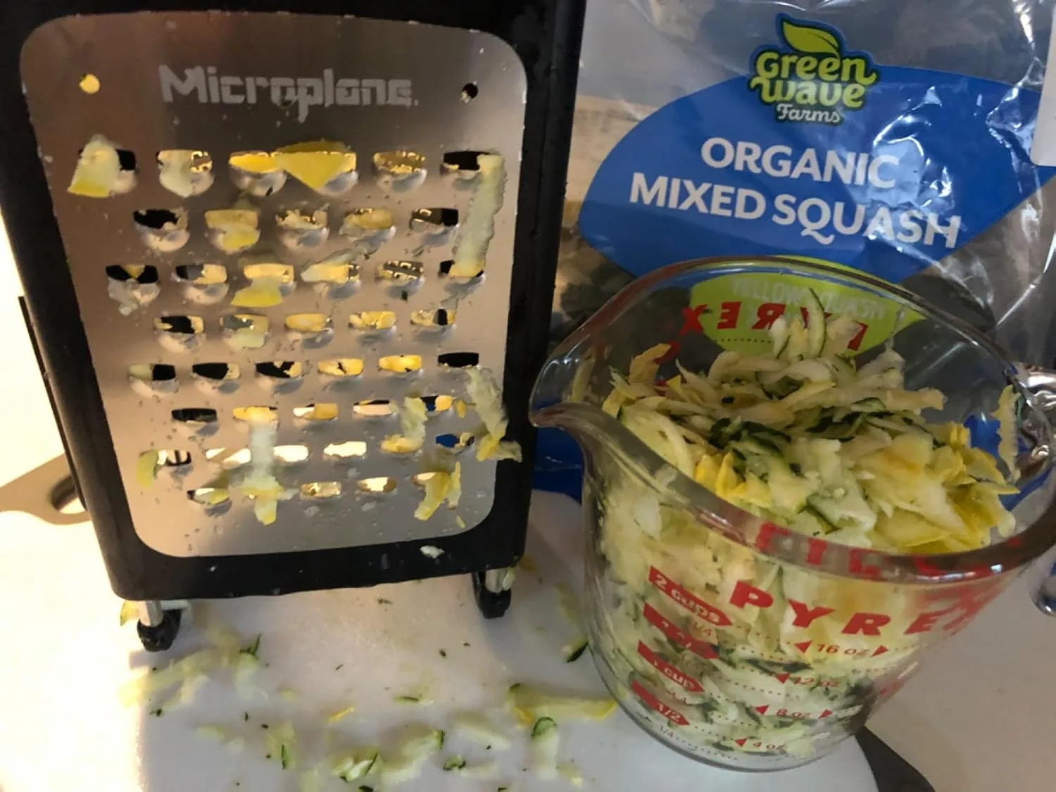 Customer photo of shredded cheese from box grater piled on wooden surface
