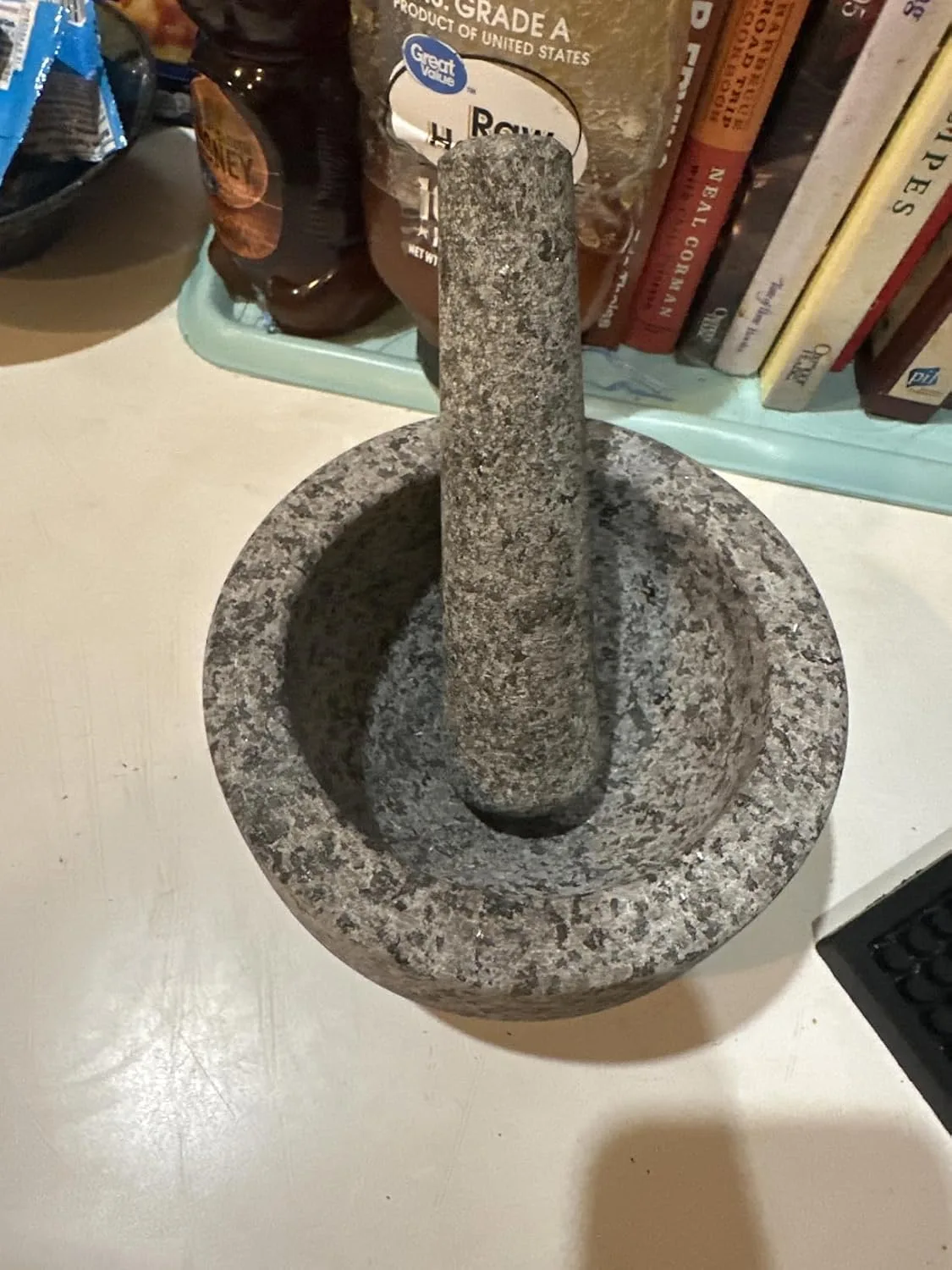 Customer photo of freshly made guacamole in mortar and pestle with avocado halves nearby